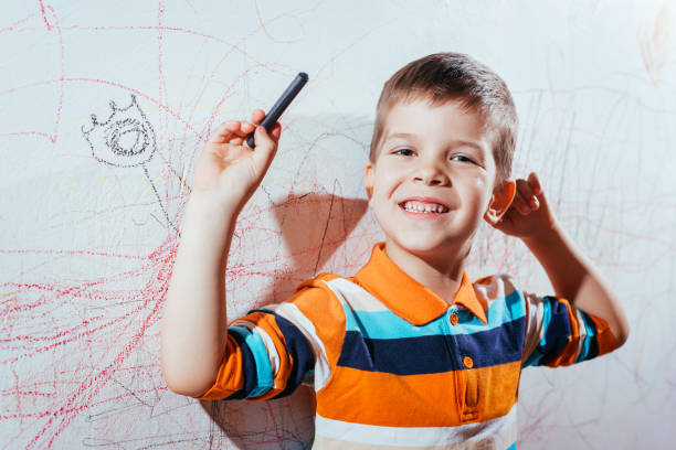 istock Smiling child draws on the wall with colored pencils 1320010245