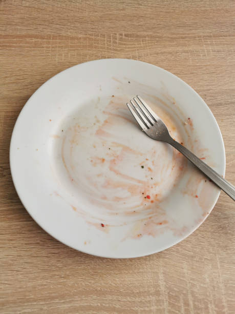 istock Dirty empty plate and fork after dinner on wooden table 1320010344
