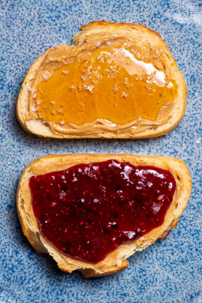 istock Honey, raspberry jam and peanut butter on white bread close up 1320011367