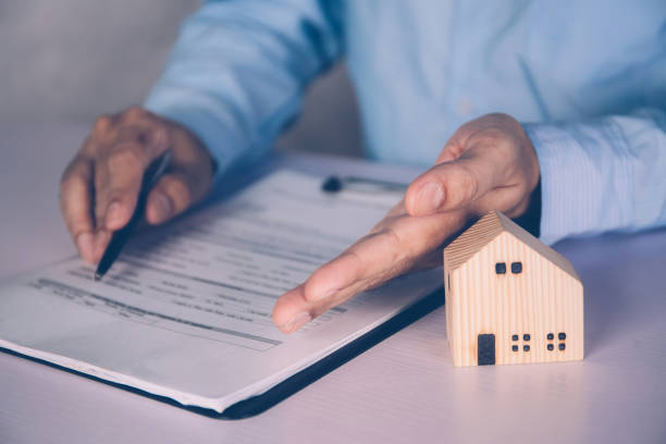 Real estate agent holding home and signing contract about agreement of real property on desk, house broker and planning investment, businessman writing on document form rent house, business concept. agente de bienes raíces que sostiene la casa y firma del contrato sobre el acuerdo de la característica inmobiliaria en el escritorio, corredor de la casa y la inversión de la planificación, hombre de negocios que escribe en la forma del documento casa