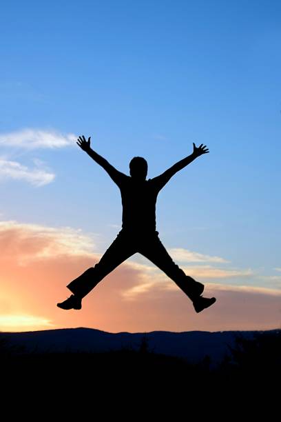istock man in a jump, in the background the sunset 1320012603