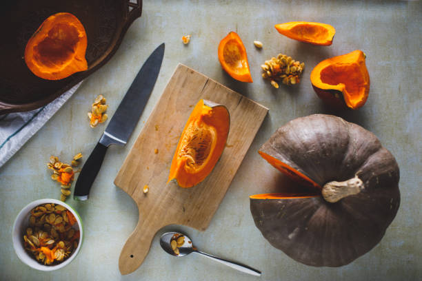 istock Pumpkin seeds and slices on a kitchen counter 1320014744