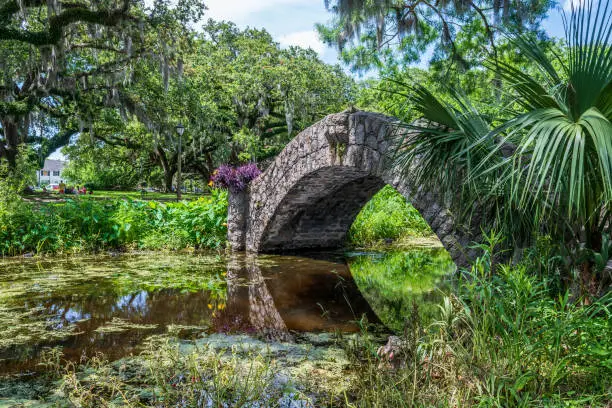 Photo of New Orleans, Louisiana - May 23, 2021: Langles Bridge in New Orleans City Park is one of three stone foot bridges in the park built in 1902.