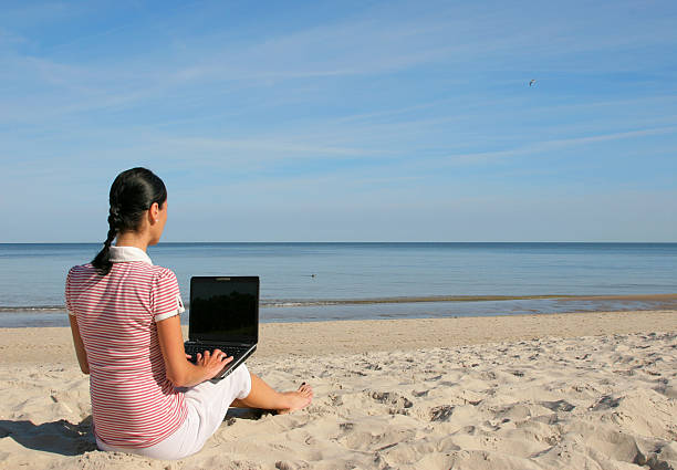 istock Woman with laptop on the beach 132002100