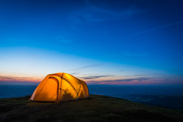 istock Warmly illuminated dome tent camping on mountain overlooking sunset valley 1320021517
