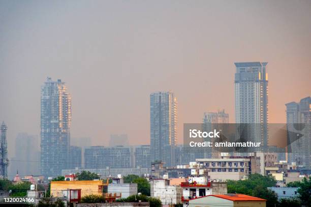 Zoomed In Shot Showing Glass Skyscrapers Multi Story Floor Tall Buildings On A Rainy Dawn Lit From The Side By Orange Sunshine Showing The Rapid Growth Of Real Estate Property In Gurgaon Delhi Mumbai Indian Cities Stock Photo - Download Image Now