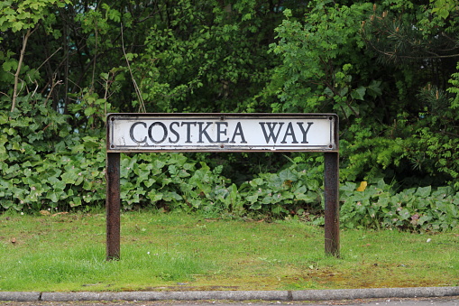 Street name sign for Costkea Way on a street between a Costco Wholesale store and an Ikea store outside Edinburgh