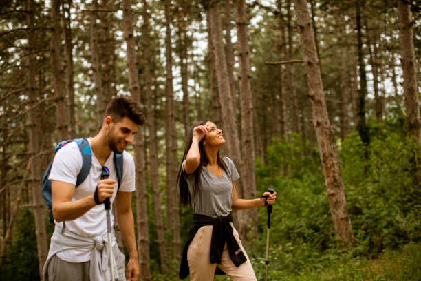 istock Smiling young couple walking with backpacks in the forest 1320030397