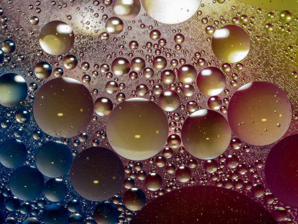 istock Oil drops in water, colored background 1320032889