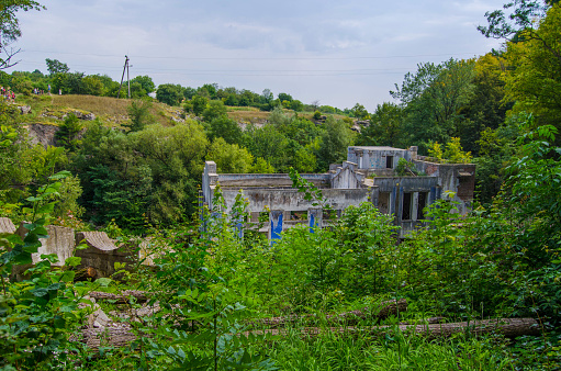 An old building of the power station among green trees, Buky Canyon Ukraine, the Hirskyi Tikych river, the Cherkasy Oblast