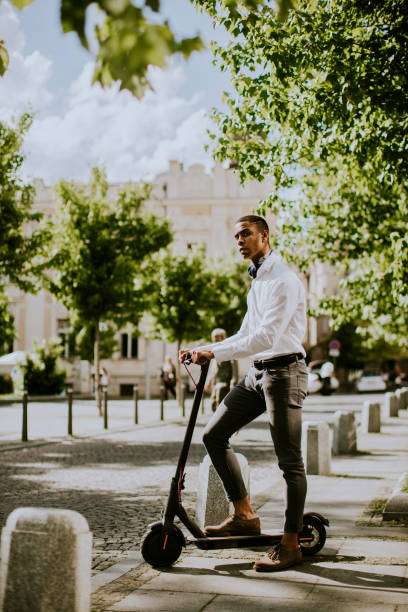 istock Young African American using electric scooter on a street 1320034814