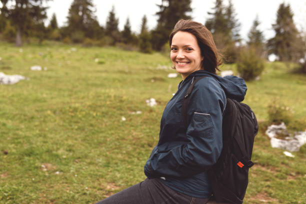 istock A woman hiking with a backpack on her back sitting and resting in nature. 1320035539