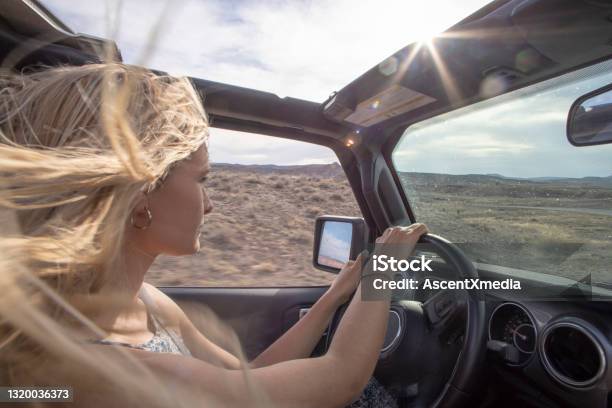 Young Woman Drives Offroad Vehicle Down Desert Road Stock Photo - Download Image Now