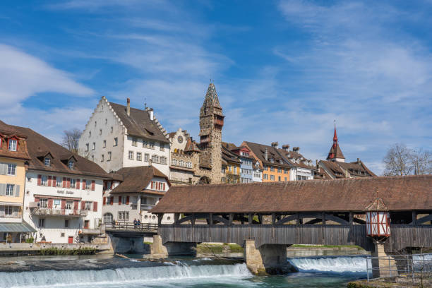 The medieval wooden bridge over Reuss river in Bremgarten, Switzerland. The medieval wooden bridge over Reuss river in Bremgarten is very known and was build 1281. Rebuild 1953. In background the house of administration of abbey Muri-Amthof with the prominent tower. aargau canton photos stock pictures, royalty-free photos & images