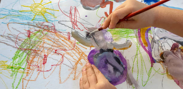 istock Close up of child's hands drawing at white paper 1320042423