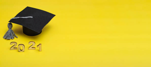 istock Graduation 2021. Graduate cap on a yellow background. Graduate Template 2021. Banner 1320042580