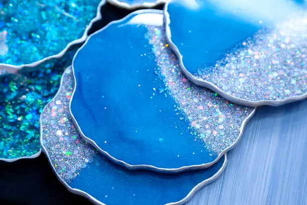 Photo of The blue coasters is made of epoxy resin. Stand, tray, or decorative element on wooden shelf