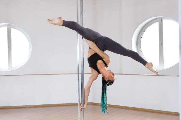 fitness pole dance workout routine im trainingsstudio. - the splits ethnic women exercising stock-fotos und bilder