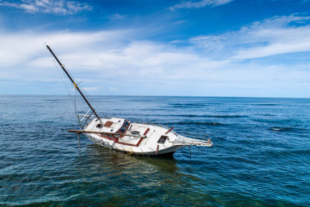 Sinking boat Grounded sailing boat hit on coral in open sea at the Caribbean ship wreck shore storm stock pictures, royalty-free photos & images