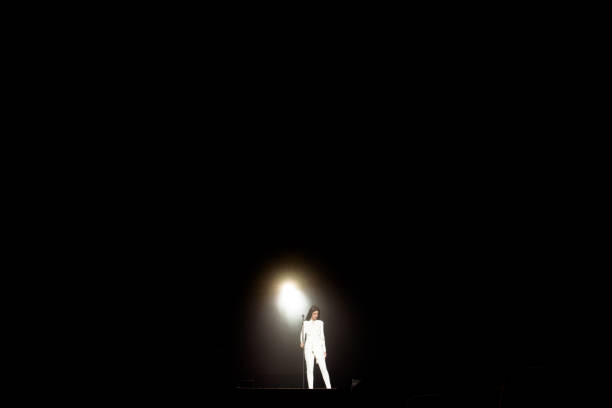 istock Singer on stage in a beam of white light. 1320049696