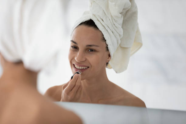 istock Happy millennial girl applying make up at mirror after shower 1320049906