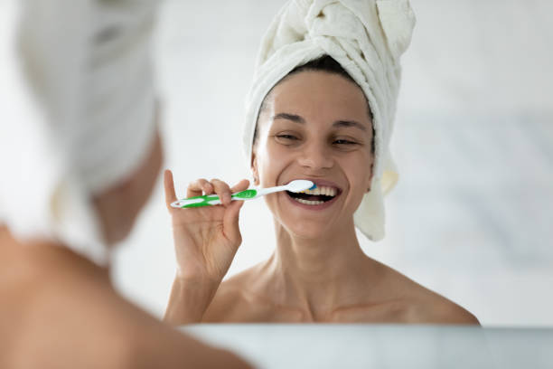 istock Joyful girl smiling while brushing perfect white teeth after shower 1320049909