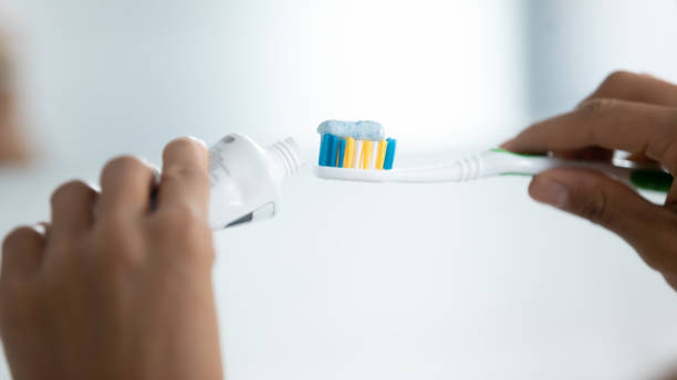 istock Hands of woman cleaning teeth, squeezing whitening paste 1320049911
