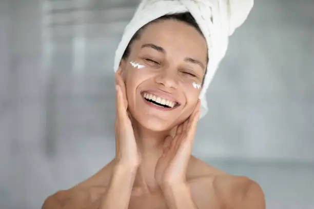 Photo of Happy excited beautiful girl enjoying facial skincare procedures