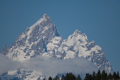 Snowcapped Grand Teton peaks in the clouds in the Grand Teton National park near Jackson Hole, Wyoming in western USA.