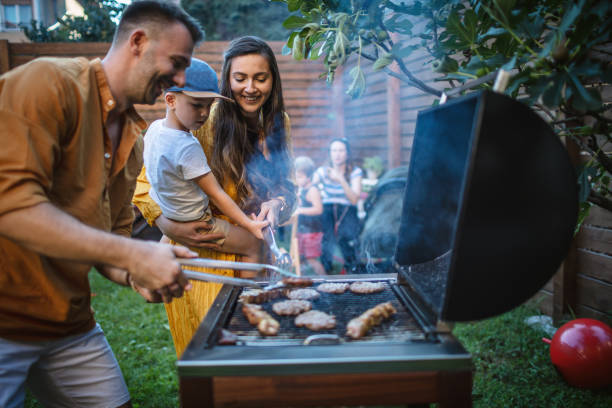 Barbecue party in backyard Photo of young happy family having a barbecue party in backyard grilled stock pictures, royalty-free photos & images