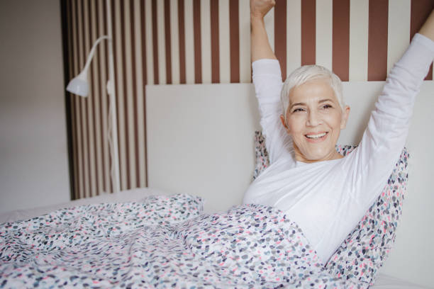 istock Beautiful senior woman is waking up in bed 1320054798