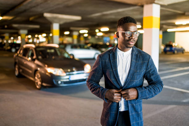 istock Young businessman standing at public car garage. 1320059396