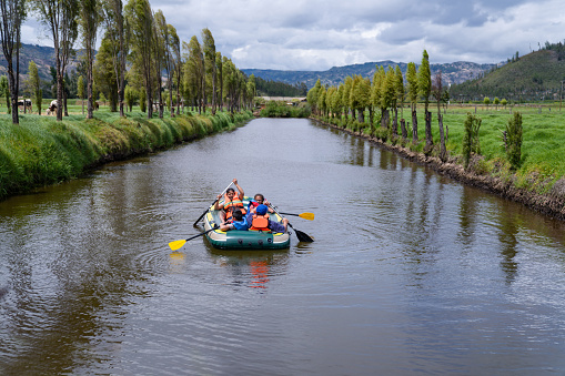 Happy Latin American family having fun rowing on a rafting boat in the water â recreational pursuit concepts