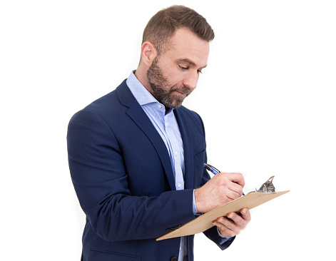 White male with beard wearing navy blue blazer writing on clipboard on white background