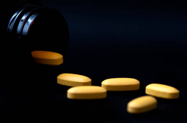 открытая бутылка таблетки с таблетками разлива - vitamin pill excess pill capsule стоковые фото и изображения