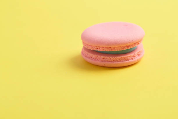 istock Pink french macaroons on bright yellow background 1320068177