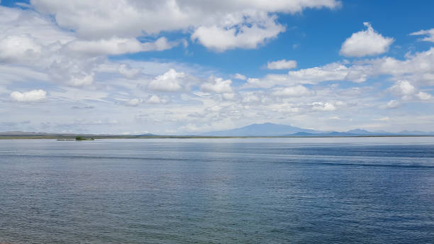 istock Clouds over the calm lake and mountains at the distance. 1320071637