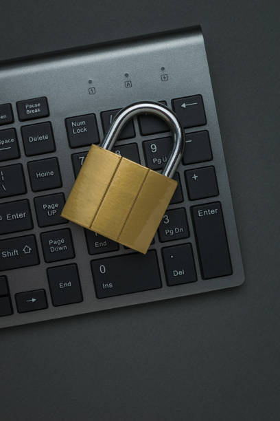 istock Closed metal lock on a computer keyboard on a dark background. Flat lay. 1320073825