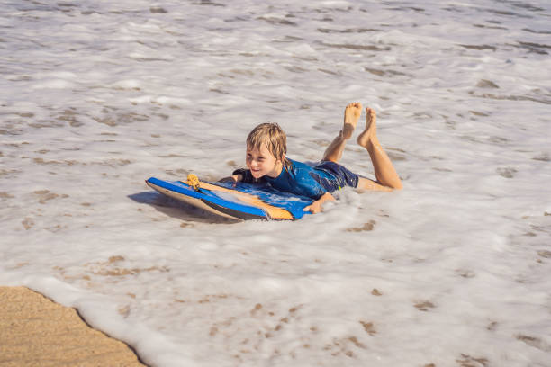 istock Happy Young boy having fun at the beach on vacation, with Boogie board 1320073943