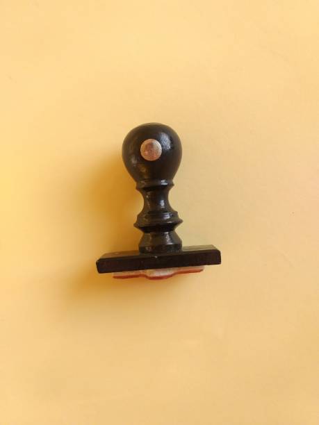 istock Black wooden stamp handle on yellow background 1320074591