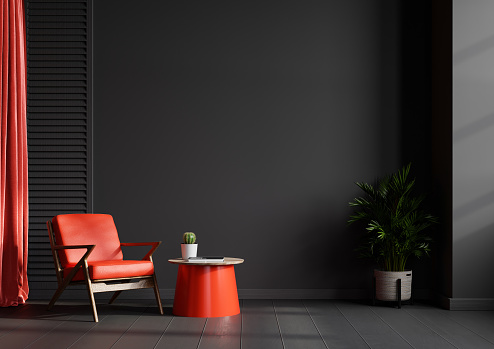 Living room interior wall mockup in black tones with red leather armchair on dark wall background.3d rendering