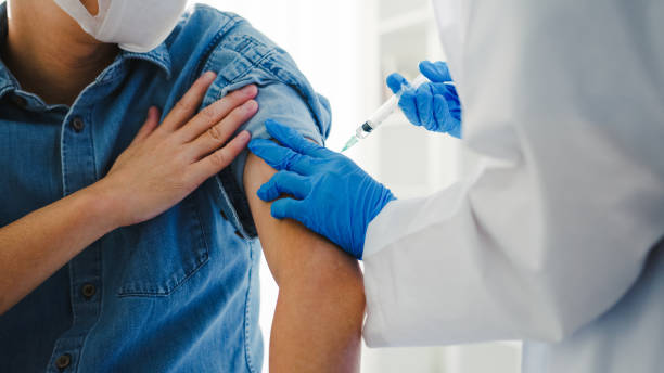 jeune médecin de dame d’asie donnant covid-19 ou vaccin antivirus de grippe tiré au patient masculin aîné portent la protection de masque facial contre la maladie de virus à la clinique de santé. - vaccin photos et images de collection