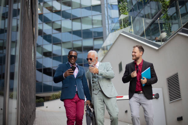 istock Three business men walking and talking outside. Man holding mobile 1320089609