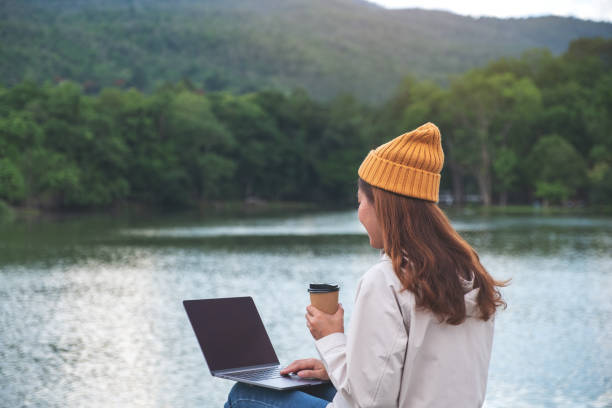 istock A young woman using and working on laptop computer while traveling mountains and lake 1320089909