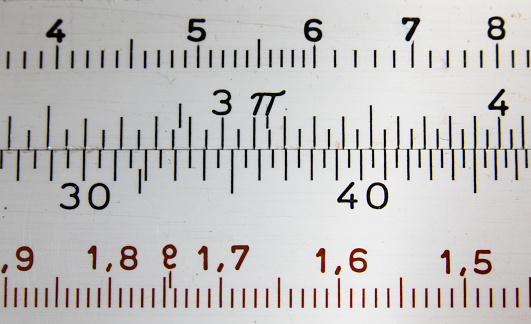 Macro image of old scratched slide rule - an old mathematical tool for calculations from before the era of electronic calculators.