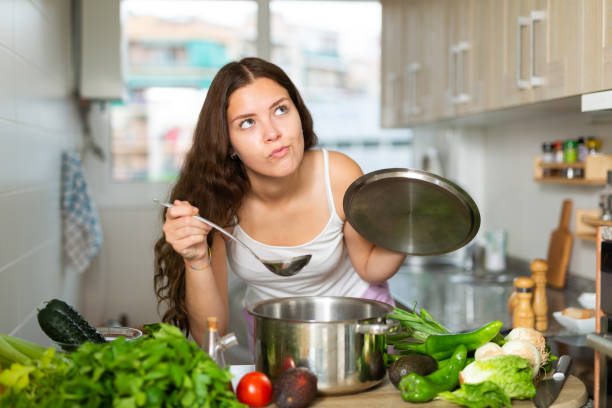 istock Woman holding cooking pot on kitchen 1320093006