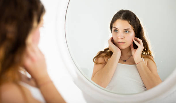 istock Girl with a towel on her head looks in mirror 1320093077