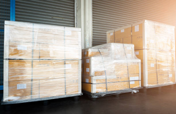 istock Stacked of Package Boxes Wrapped Plastic Flim on Plastic Pallets at Storage Warehouse. Shipment Boxes. Cargo Export- Import. Shipping Warehouse Logistics. 1320093183
