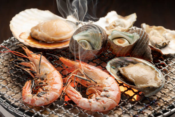 cuire les fruits de mer sur le feu de charbon de bois du poêle à barbecue - food shrimp barbecue grill seafood photos et images de collection
