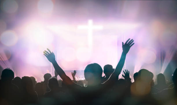 cristianos levantando la mano en alabanza y adoración en el fondo cruzado - espectador fotos fotografías e imágenes de stock